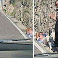 Positano, turista aspetta bus disteso sul ciglio della strada